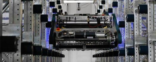 Photograph of the Fraunhofer RackRacer shuttle moving both horizontally and diagonally on warehouse racking.